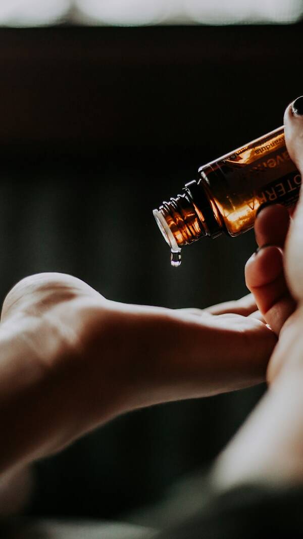 person holding amber glass bottle