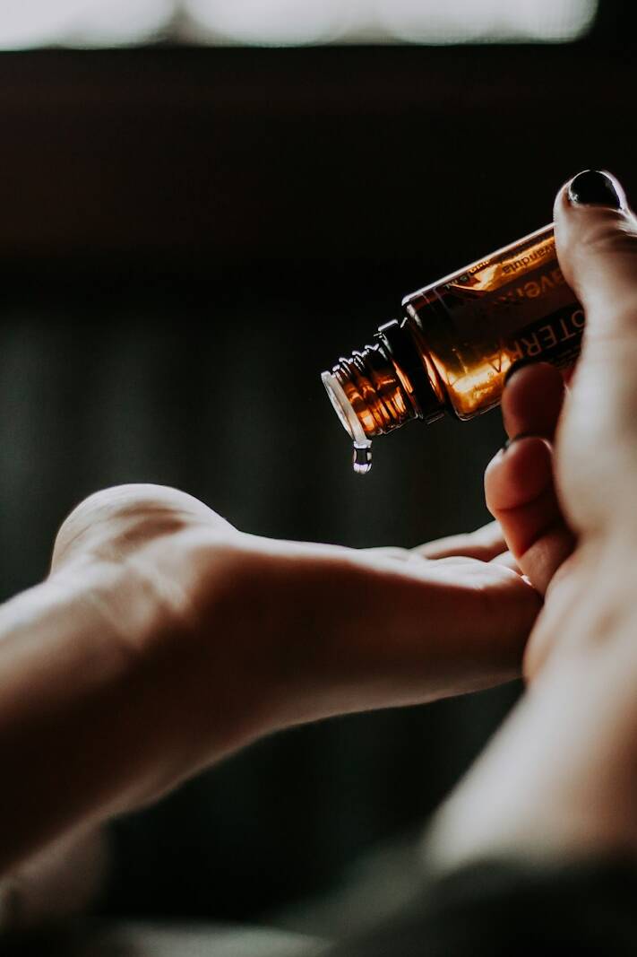 person holding amber glass bottle