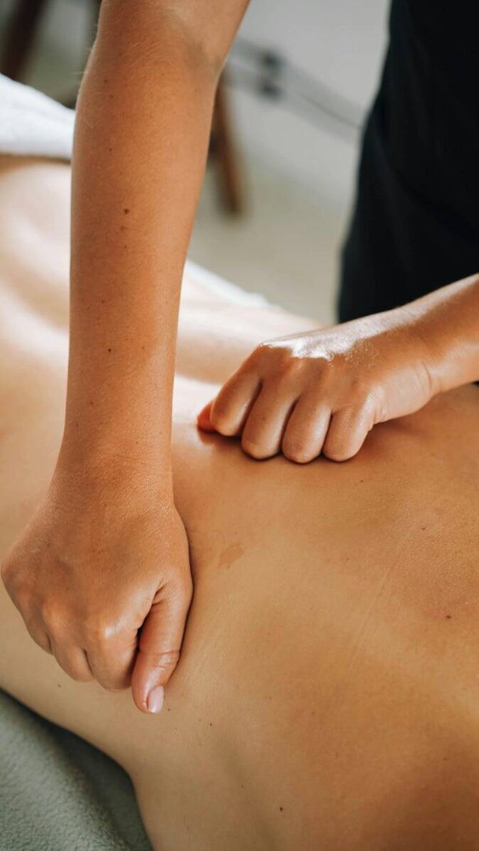A massage therapist provides a back massage.