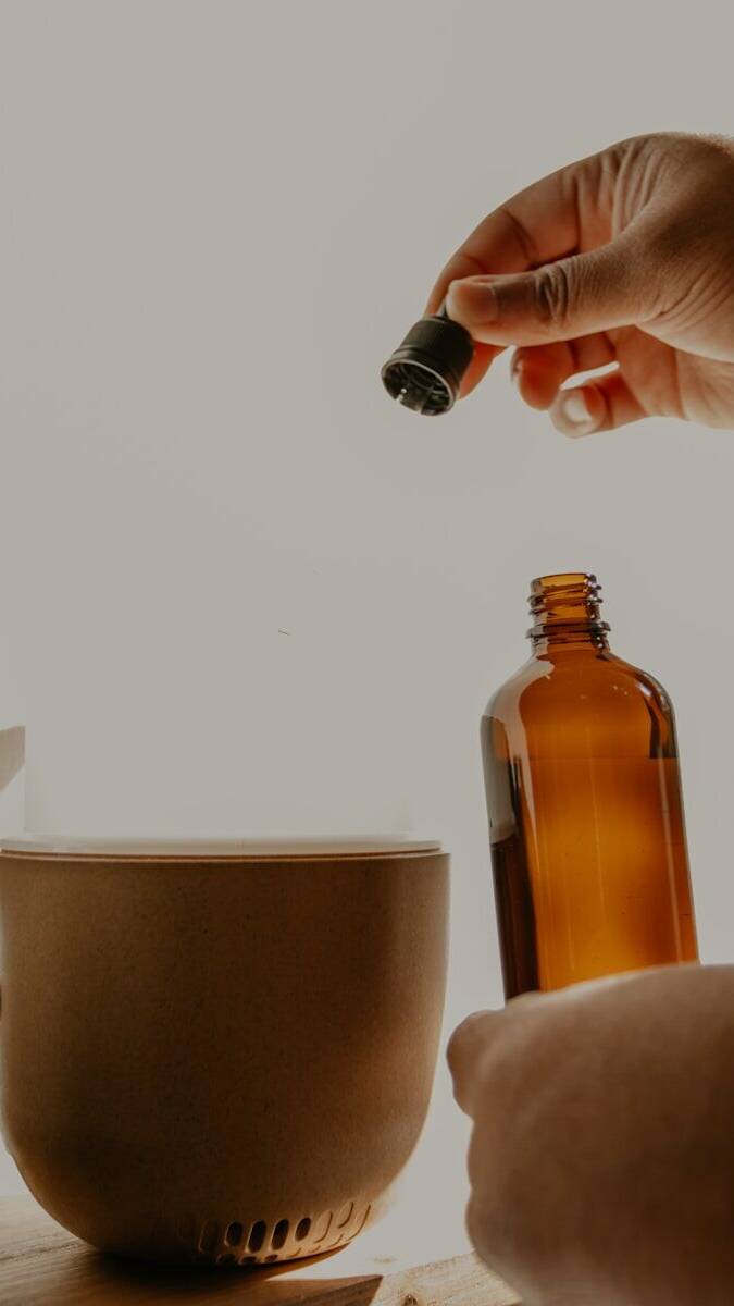 person holding brown glass bottle
