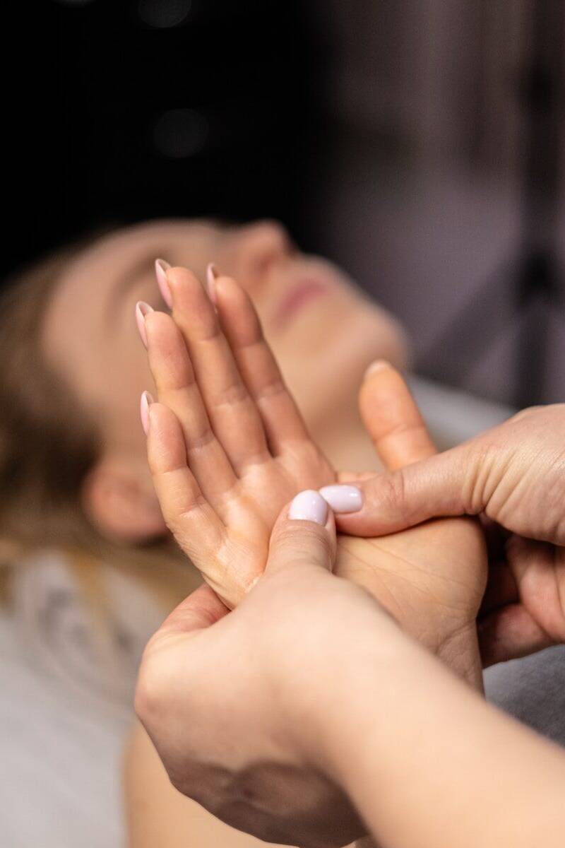 a woman laying on a bed with her hands together